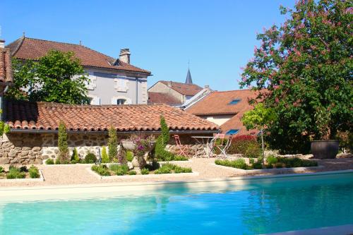 a house with a swimming pool in front of a yard at La Châtaigne in Piégut-Pluviers