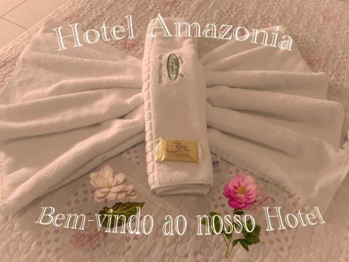a white towel laying on top of a white blanket at Hotel Amazonia in Castanhal