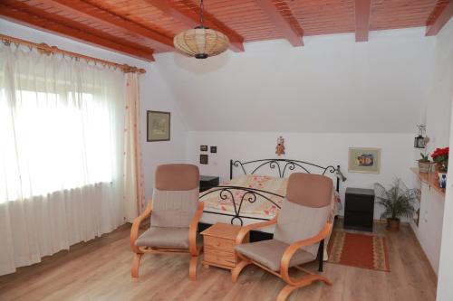 a bedroom with a bed and two chairs at Raza Soarelui in Sovata