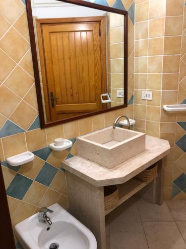 y baño con lavabo y espejo. en CASA LA TANCA en Isola Rossa