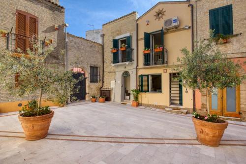 a courtyard in an old building with trees in pots at Residenza Amblingh in Vasto