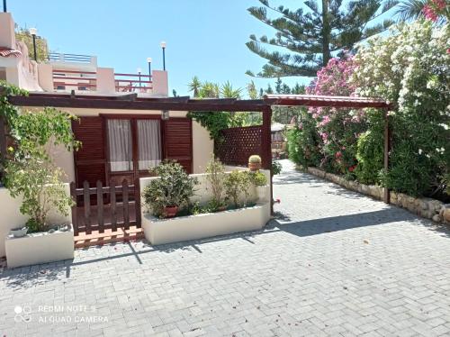 a patio with potted plants and a pergola at Alexandros Studios in Kalamaki Chanion