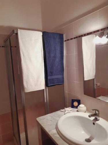 アルゲーロにあるBrisa Marina apartmentのバスルーム(シンク、シャワー、青いタオル付)