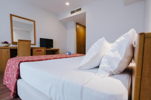 a bedroom with two beds with white pillows at Hotel Premium Porto Maia in Maia