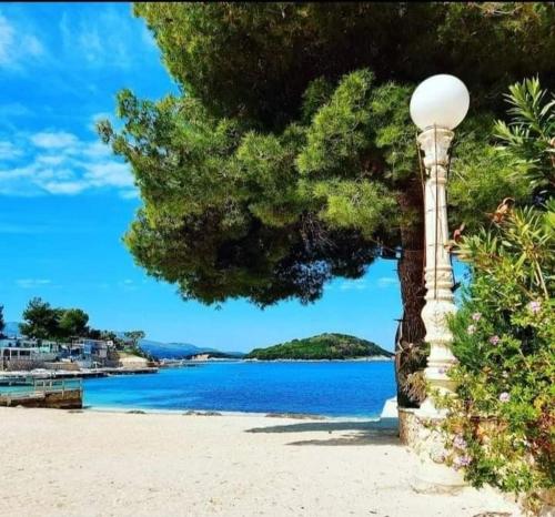 ein Straßenlicht an einem Strand in der Nähe des Wassers in der Unterkunft Hotel Adriatik Ksamil in Ksamil