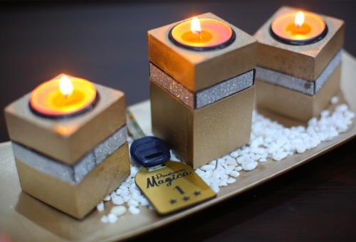three candles are sitting on a plate with flowers at Vila Magica in Constanţa