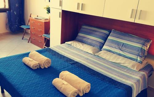 アルゲーロにあるBrisa Marina apartmentのベッドルーム1室(ブルーベッド1台、タオル付)