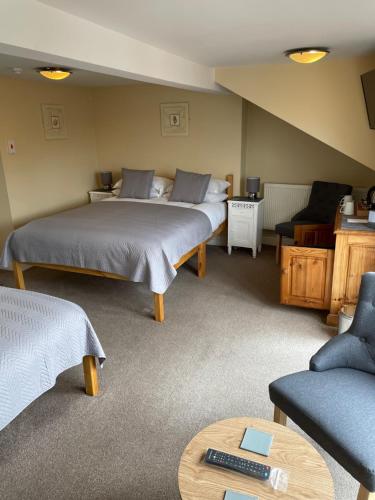 a room with two beds and a couch and a table at The Courtyard Guest House in Great Yarmouth