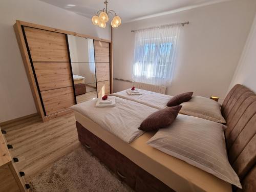 a bedroom with a large bed with a mirror at Apartman Tea in Privlaka