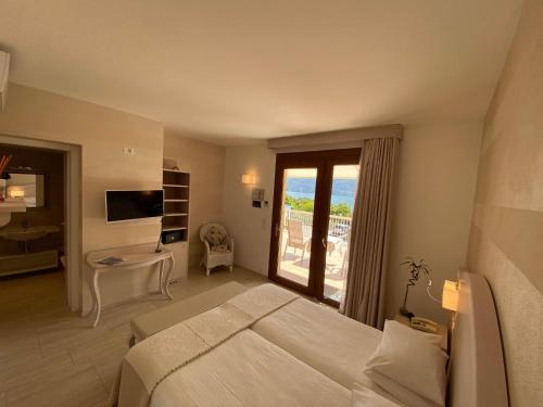 a bedroom with a large bed and a balcony at Hotel Riviera Panoramic Green Resort in Limone sul Garda