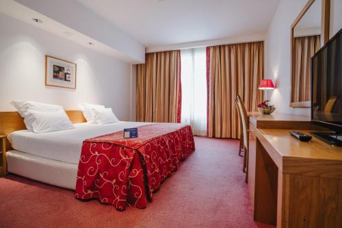 Pokój hotelowy z łóżkiem i biurkiem w obiekcie Hotel Premium Porto Maia w mieście Maia
