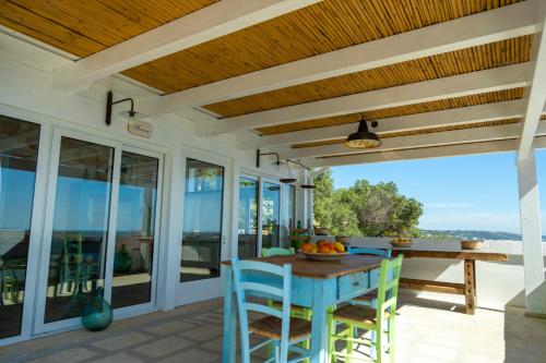 une salle à manger avec une table et des chaises sur une terrasse dans l'établissement Casa Vacanze De Vita - Amazing view on the coast - Suite with outdoor Jacuzzi, à Marina Serra