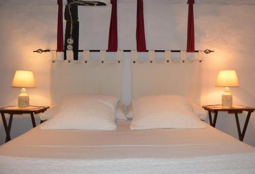 a bed with two white pillows and two lamps at Casa Bethona in Jerte
