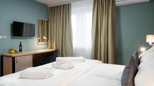 a hotel room with a bed with towels on it at Hotel Karolina in Lanškroun