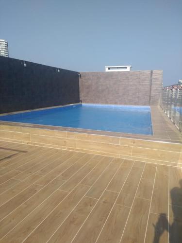 una grande piscina blu con pavimento in legno di Práctico Smart Studio a Santa Cruz de la Sierra