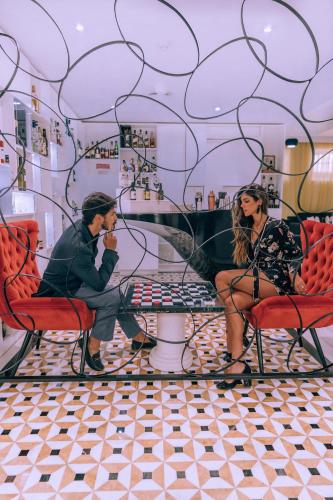 a man and woman sitting in chairs in a room at Alentejo Marmòris Hotel & Spa in Vila Viçosa