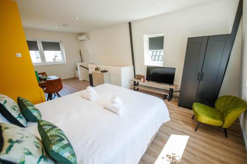 a bedroom with a large white bed and a living room at Deluxe 35m2 City Center Suite - with Views in Den Bosch