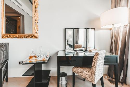 a desk in a room with a mirror and a chair at Alentejo Marmòris Hotel & Spa in Vila Viçosa