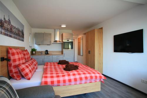 Schlafzimmer mit einem Bett mit einer roten und weißen Decke in der Unterkunft Überlinger See-Apartments Apartment 1 Über-See in Überlingen