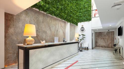 a lobby with a reception desk with a green wall at Alentejo Marmòris Hotel & Spa, a Small Luxury Hotel of the World in Vila Viçosa