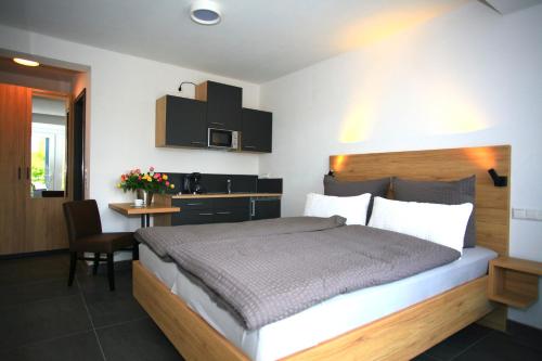 Un dormitorio con una cama y un escritorio y una cocina. en Überlinger See-Apartments Apartment 10 Über-See, en Überlingen