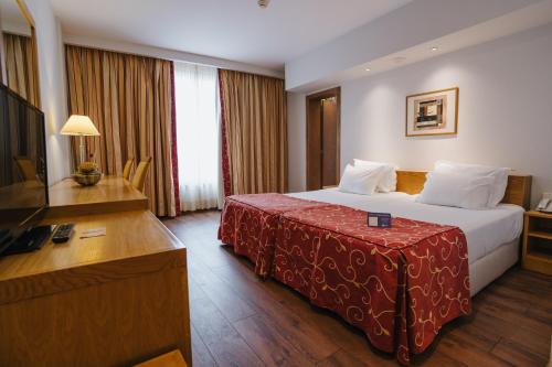 a hotel room with a large bed and a large window at Premium Porto Maia in Maia