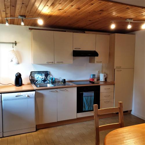 une cuisine avec des appareils blancs et un plafond en bois dans l'établissement The View Fellering, à Fellering