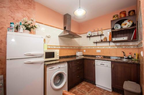 a kitchen with a white refrigerator and a washer at Casa Les Pedroses in Campiellos
