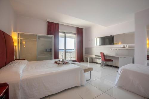 a large hotel room with two beds and a desk at Grand Hotel Salerno in Salerno