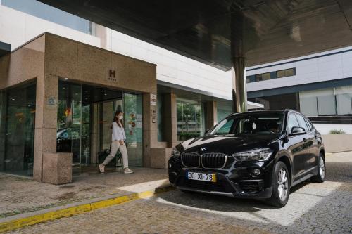 a black car parked in front of a store at Hotel Premium Porto Maia in Maia