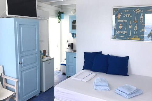 a bedroom with a white bed with blue pillows at Blue Moon Villa in Imerovigli