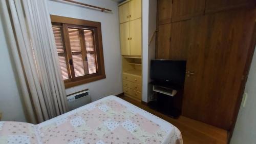 a small bedroom with a bed and a television at Apartment Ficher Sobrinho in Gramado