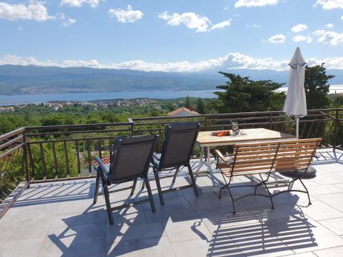 a patio with a table and chairs on a balcony at Apartments Olivia & Navy, Šilo in Šilo