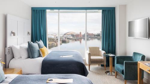 a hotel room with two beds and a large window at voco St. David's Cardiff by IHG in Cardiff
