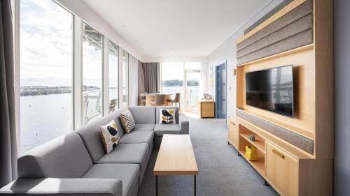 a living room with a couch and a tv at voco St. David's Cardiff by IHG in Cardiff