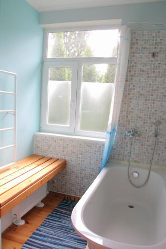 a bathroom with a bath tub and a window at Family Apartments in Jūrmala
