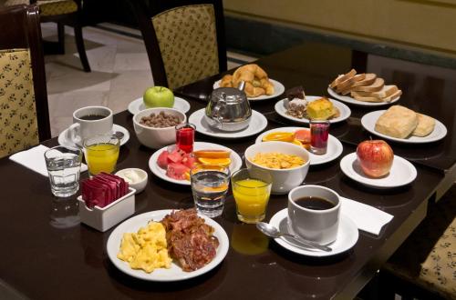 a table with plates of breakfast food on it at Amérian Executive Hotel Mendoza in Mendoza