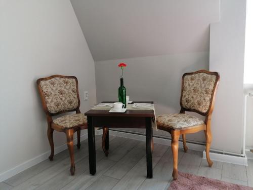 a dining room table with two chairs and a bottle of wine at Pokoje Alicja Ustka in Ustka