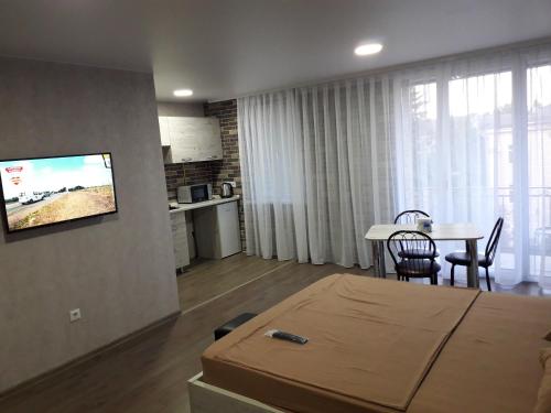 a room with a bed and a table and a television at Stefan 16-50 in Bălţi