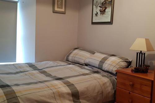 a bedroom with a bed and a lamp and a dresser at Cosy Townhouse on The Hill in Ireland in Banagher