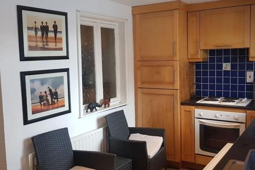 a kitchen with chairs and pictures on the wall at Cosy Townhouse on The Hill in Ireland in Banagher
