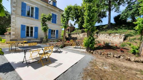 a table and chairs in front of a house at Villa du Cerf Thibault in Le Blanc