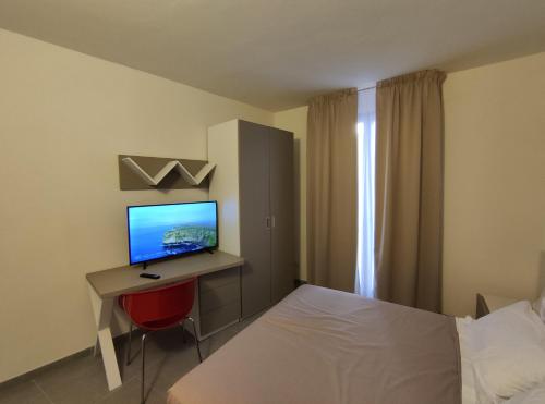 a bedroom with a bed and a desk with a computer at Xeniahome in Castelvetrano Selinunte