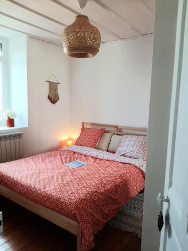 une chambre avec un lit avec une couette rouge dans l'établissement Le p'tit Opale à 2mn de la mer, à Wimereux
