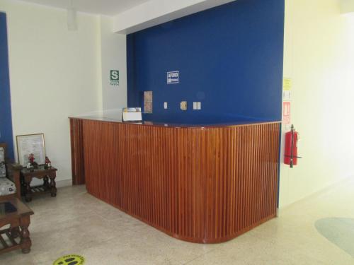 eine Lobby mit einer blauen Wand und einer Holztheke in der Unterkunft Hotel Villa Santa Ana in Quillabamba