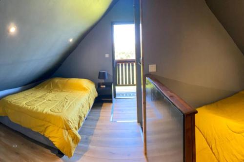 Schlafzimmer im Dachgeschoss mit 2 Betten und einem Fenster in der Unterkunft Agréable chalet Au milieu des sapins in La Plaine des Cafres