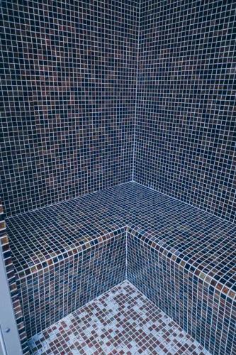 a corner of a shower with a blue tile wall at Ribarski konaci in Doboj