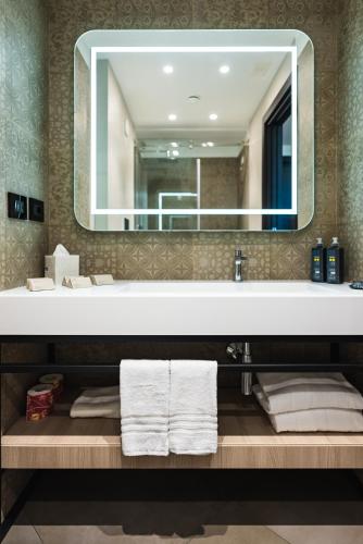 a bathroom with a sink with a mirror and towels at Salina Hotel in Taranto