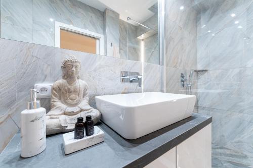 a bathroom with a sink and a statue in it at Apartmán Ostrava in Ostrava