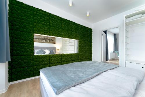 pared de acento verde en un dormitorio con cama en Apartmán Ostrava en Ostrava